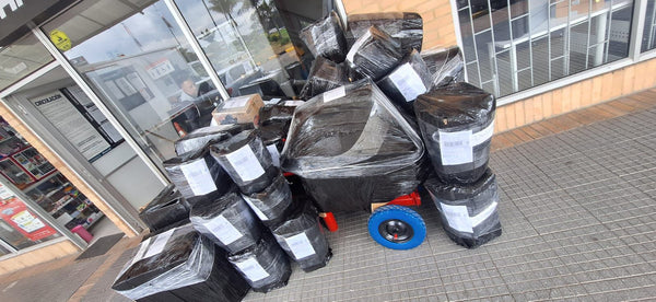 Baldes lecheros de 11 litros en fila, listos para entregar a la transportadora — foto real