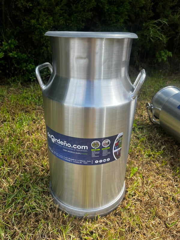 Cantina lechera de aluminio deOrdeño con tapa de caucho, en el pasto — foto real