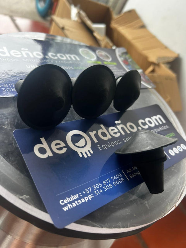 Tapones de pezonera de caucho negro sobre la tarjeta de deOrdeño — foto real