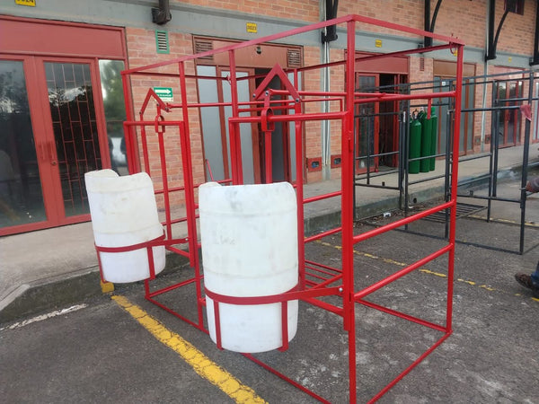 Establo de ordeño fijo en hierro rojo con dos comederos plásticos blancos al frente — foto real