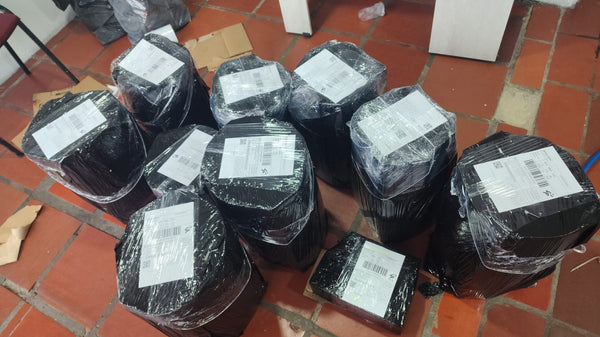 Baldes lecheros protegidos en la base con cartón para que no se golpeen en el envío — foto real