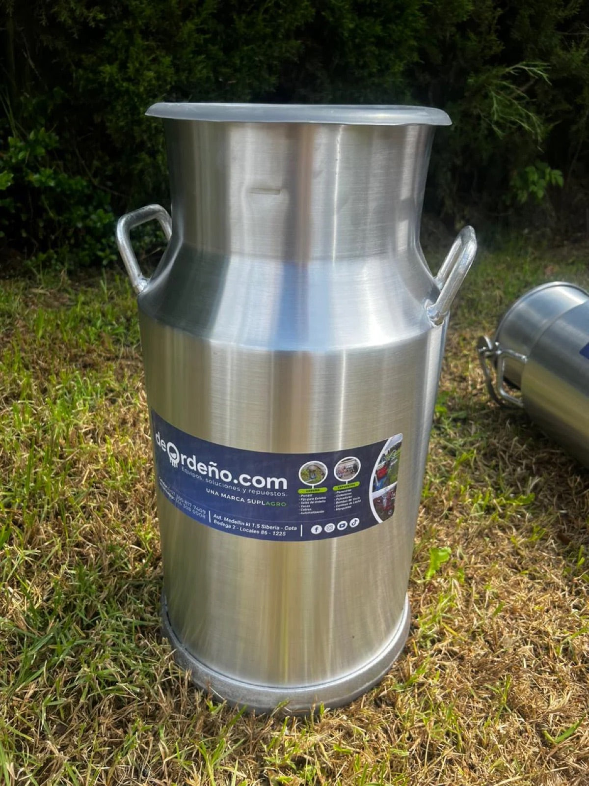 Cantina lechera de aluminio deOrdeño con tapa, en el campo