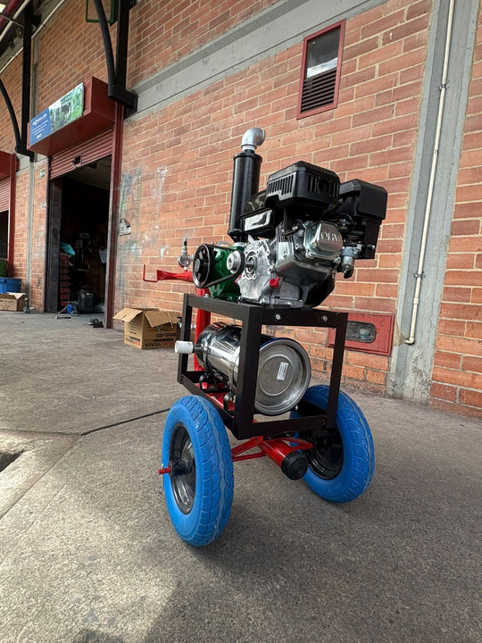 Equipo de ordeño Ecomilk Premium visto de frente: chasis rojo, motor a gasolina de 6.5 hp, bomba de vacío verde y llantas macizas azules