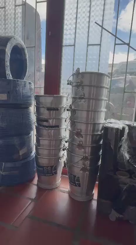 Rollos de manguera transparente para ordeño en la bodega de deOrdeño, junto a cantinas y baldes